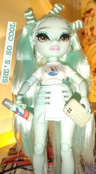 pale turquoise fashion doll in a skirt and white top, holding a waterbottle and phone. Text says 'she's so cool'