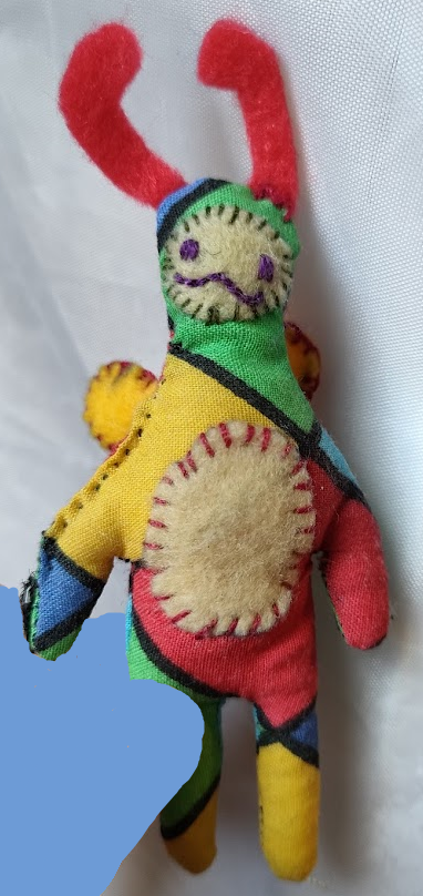 Small soft toy with a smooth harlequin fabric, antennae and a friendly expression.