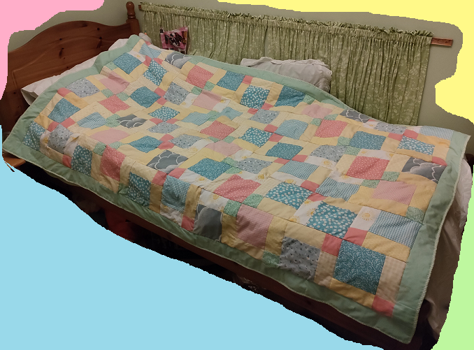 Blue, pink and yellow quilt on a single bed.